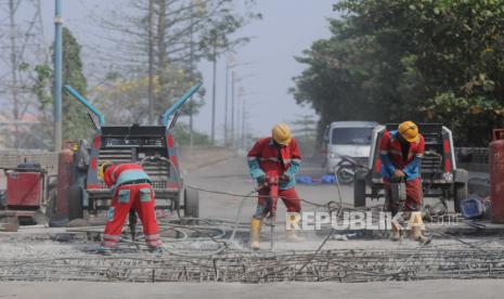 Pekerja menyelesaikan perbaikan jembatan ambles di Jalan Akses Marunda, Cilincing, Jakarta Utara, Rabu (21/6/2023). Jembatan Marunda dari arah Bekasi menuju Cilincing mengalami kerusakan jebol pada bagian aspal hingga ambles dengan diameter sekitar satu meter. Dampak dari perbaikan jembatan tersebut membuat kemacetan hingga harus diberlakukan rekayasa arus lalu lintas dan contraflow untuk mengurai kemacetan.