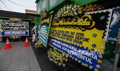 Pelajar berjalan di dekat karangan bunga di SMK Lingga Kencana, Depok, Jawa Barat. Menhub sebut kolaborasi lintas sektor penting untuk cegah kecelakaan bus pariwisata.