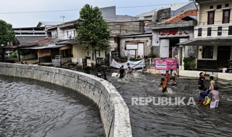 Anak-anak bermain saat banjir akibat luapan air sungai di Jakarta (ilustrasi). BPBD DKI mengingatkan warga potensi banjir akibat luapan sungai.