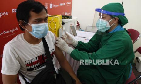 Petugas kesehatan menyuntikkan vaksin COVID-19 pada penerima vaksin saat acara Melangkah Untuk Vaksinasi di Gelora Manahan Solo, Jawa Tengah, Rabu (18/8/2021). Guna memberikan kekebalan imunitas bagi warga dalam penanganan pandemi COVID-19, Menteri Koordinator Bidang Maritim dan Investasi Luhut Binsar Pandjaitan menargetkan capaian vaksinasi COVID-19 di Soloraya sebesar 75 persen pada akhir bulan Agustus 2021. 