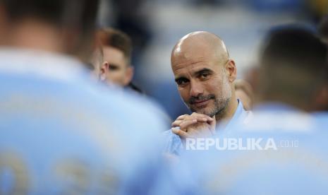 Pelatih kepala Manchester City Pep Guardiola berhenti sejenak untuk merayakan kemenangan gelar Liga Premier Inggris setelah pertandingan sepak bola antara Manchester City dan Everton di stadion Etihad di Manchester, Ahad (23/5).