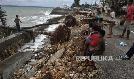 Sejumlah warga berada di jalan penghubung antara 3 kabupaten wilayah kepulauan yang rusak usai dihantam ombak tinggi di Pantai Batauga, Kecamatan Batauga, Buton Selatan, Sulawesi Tenggara, Selasa (22/2/2022). Dampak gelombang tinggi disertai angin kencang terjadi pada Senin (21/2/2022) mengakibatkan beberapa fasilitas umum dan akses jalan penghubung Kabupaten Buton, Buton Selatan, dan Kota Baubau rusak. 