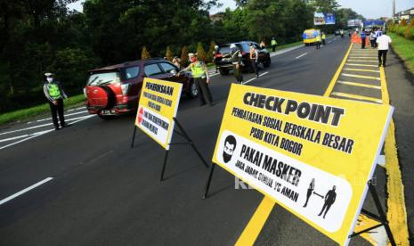 Petugas memeriksa kendaraan saat pelaksanaan Pembatasan Sosial Berskala Besar (PSBB) hari pertama di Kota Bogor, Rabu (15/4). Kepolisian sudah mendirikan pos-pos penjagaan untuk memeriksa warga yang berkegiatan di jalan