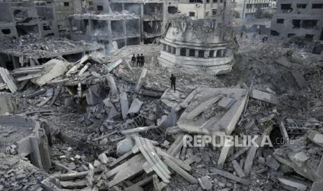 Warga Palestina memeriksa puing-puing Masjid Yassin yang hancur pasca terkena serangan udara zionis Israel di kamp pengungsi Shati di Kota Gaza, Senin (9/10/2023) dini hari.