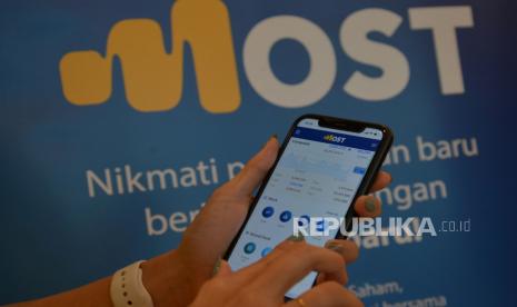 Model membuka aplikasi digital MOST (Mandiri Online Securities Trading) dengan tampilan yang baru di Jakarta, Rabu (30/11/2022). Direktur PT Mandirl Sekuritas Theodora Manik memproyeksikan pasar obligasi Indonesia pada 2023 akan lebih cerah setelah berhasil menunjukkan resiliensi di tahun sebelumnya.