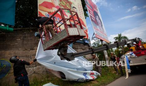 Petugas Bawaslu dibantu Satuan Polisi PP menertibkan alat peraga kampanye (APK)  yang dipasang tidak sesuai aturan kampanye (ilustrasi)