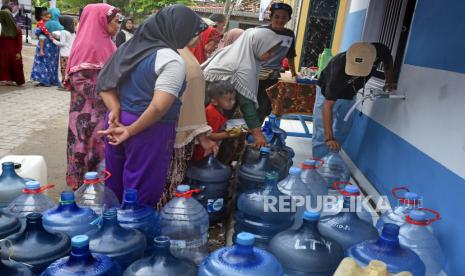 Sejumlah warga antre mengambil air bersih usai peresmian bantuan instalasi air bersih untuk warga oleh Menteri Sosial Tri Rismaharini di Kampung Cikedung, Kasemen, Serang, Banten, Selasa (4/10/2022). Mensos secara simbolis meresmikan penyaluran bantuan empat instalasi air bersih di Kabupaten Serang untuk memenuhi kebutuhan air minum bagi warga tepi pantai yang sumber airnya payau akibat resapan air laut. 