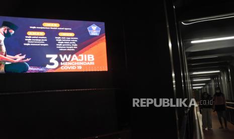 Dua warga melintas di dekat videotron penyuluhan protokol kesehatan di Jakarta, Rabu (28/10/2020). Berdasarkan data Satgas Penanganan COVID-19 pada Rabu (28/10), jumlah terkonfirmasi COVID-19 di Indonesia meningkat 4.029 kasus atau total menjadi 400.483 kasus sedangkan kasus sembuh juga meningkat 3.545 kasus sehingga total kasus sembuh menjadi 325.793 orang. 