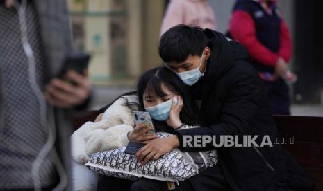 Warga yang memakai masker untuk membantu melindungi diri dari virus korona yang berjalan di sepanjang jalan di Wuhan di provinsi Hubei China tengah pada hari Kamis, 14 Januari 2021. Tim peneliti global untuk Organisasi Kesehatan Dunia tiba Kamis di kota China tempat pandemi virus corona. pertama kali terdeteksi untuk melakukan penyelidikan yang sensitif secara politis tentang asal-usulnya di tengah ketidakpastian tentang apakah Beijing mungkin mencegah penemuan yang memalukan.