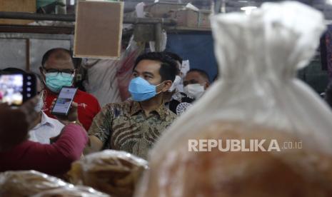 Wali Kota Solo Gibran Rakabuming Raka (kanan) melakukan transaksasi digital dengan aplikasi pembayaran kepada pedagang dalam kegiatan Adipati Qris rangkaian Solo Great Sale di Pasar Gede Solo, Jawa Tengah, Jumat (3/9/2021). Guna mempercepat pemulihan ekonomi saat pandemi COVID-19 di Kota Solo, Pemkot Solo akan menggelar Solo Great Sale selama bulan Oktober 2021 dengan target transaksi Rp800 miliar. 