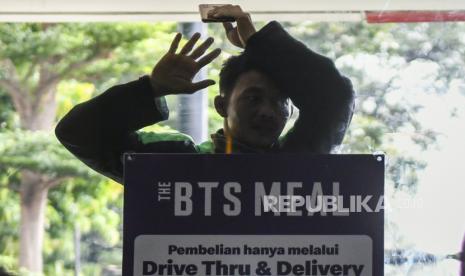 Seorang pengemudi ojek daring mengantre untuk mengambil pesanan di gerai McDonald’s Raden Saleh, Jakarta, Rabu (9/6/2021). Puluhan pengemudi  ojek daring tersebut terlihat mengabaikan protokol kesehatan saat mengantre untuk mengambil pesanan BTS Meal yang merupakan menu kolaborasi boy band asal Korea BTS dengan McDonald