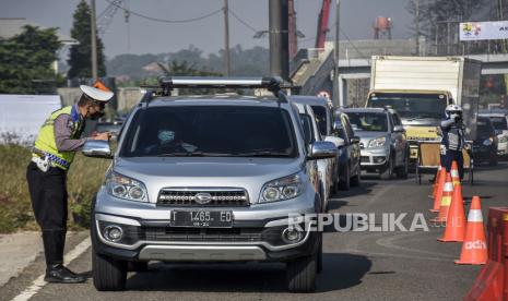 Petugas gabungan memeriksa identitas dan surat keterangan negatif Covid-19 dari pengemudi kendaraan dengan pelat nomor dari luar Bandung di gerbang keluar Tol Cileunyi, Kabupaten Bandung, Senin (26/4). Penyekatan yang dilakukan oleh petugas gabungan dari Satlantas Polresta Bandung, Dishub Kabupaten Bandung dan Satpol PP Kabupaten Bandung tersebut merupakan bagian dari pelaksanaan larangan mudik yang resmi berlaku mulai Sabtu 24 April 2021 hingga 22 Mei 2021. Foto: Republika/Abdan Syakura