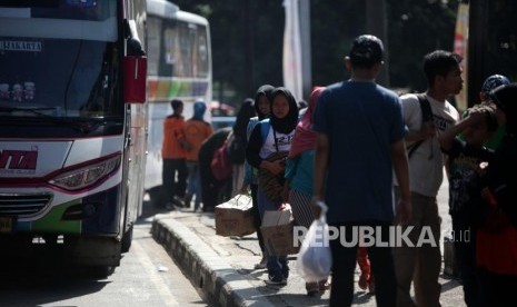 Pemudik berjalan seusai turun dari bus di Terminal Kampung Rambutan, Jakarta, Senin (18/6).