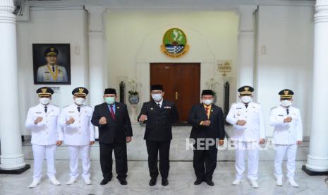 Gubernur Jawa Barat Ridwan Kamil (tengah) dan Wakil Gubernur Jawa Barat Uu Ruzhanul Ulum (ketiga kanan) berfoto bersama usai pelantikan Dadang Supriatna dan Sahrul Gunawan sebagai Bupati dan Wakil Bupati Bandung periode 2021–2026, serta Bupati dan Wakil Bupati Tasikmalaya Ade Sugianto dan Cecep Nurul Yakin, di Gedung Sate, Kota Bandung, Senin (26/4). Pada Kesempatan itu Gubernur berpesan agar kepala daerah yang baru dilantik senantiasa menjaga kekompakan dab segera bekerja salah satunya fokus terhadap penanggulangan pandemi Covid-19.