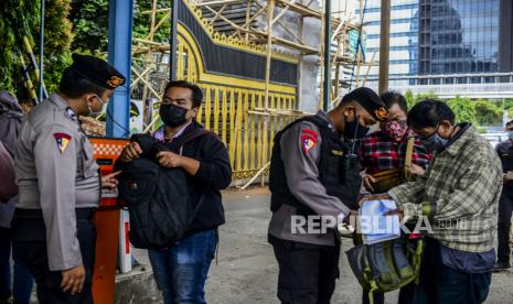 Sejumlah anggota kepolisian memeriksa tas yang dibawa oleh pengunjung di Mapolda Metro Jaya, Jakarta, Kamis (1/4). Polda Metro Jaya memperketat akses masuk ke wilayah tersebut dengan melakukan pemeriksaan barang bawaan pengunjung dan pengamanan menggunakan anggota bersenjata untuk mengantisipasi ancaman teror pasca kejadian penyerangan di Mabes Polri. Republika/Putra M. Akbar