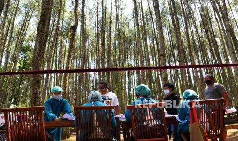 Tenaga kesehatan melayani pendaftaran vaksinasi pelaku wisata di kawasan wisata Hutan Pinus Mangunan, Bantul Yogyakarta, Rabu (28/7). Sebanyak dua ribu pelaku wisata menjadi target vaksinasi massal Covid-19 oleh Pemerintah Kabupaten Bantul. Pada vaksinasi massal kali ini menggunakan vaksin Sinovac.