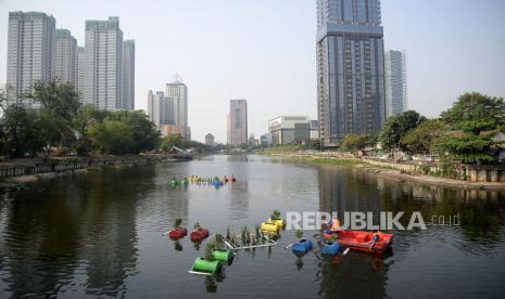 Petugas Suku Dinas Sumber Daya Air (SDA) Jakarta Pusat menyiram tanaman yang berada di Pot Apung atau Floating Forest di Waduk Melati, Jakarta, Jumat (6/10/2023). Penghijauan waduk dengan sistem pot apung tersebut diharapakan mampu mengurangi polusi sekaligus diharapkan menjadi daya tarik sendiri bagi waduk melati. Sistem pot apung ini diterapkan sejak satu minggu lalu dengan memanfaatkan pipa paralon dan drum bekas.