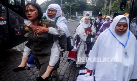 Petugas Satpol PP menggendong jamaah calon haji menuju bus saat pelepasan keberangkatan di halaman Pemkab Bogor, Cibinong, Kabupaten Bogor, Jawa Barat, Rabu (22/5/2024). Sebanyak 432 jamaah calon haji Kabupaten Bogor kelompok terbang (kloter) 25 diberangkatkan menuju embarkasi haji Bekasi dan selanjutnya terbang menuju tanah suci Mekah.