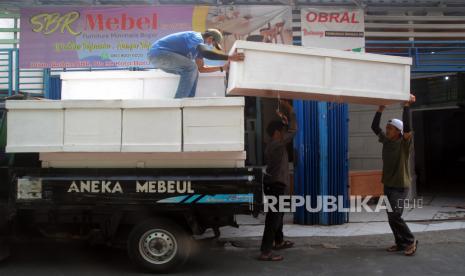 Pekerja mengangkat peti jenazah khusus pasien Covid-19 di Kampung Cibogel, Desa Kota Batu, Ciomas, Kabupaten Bogor, Jawa Barat. Menurut pengusaha meubeul yang beralih memroduksi peti jenazah tersebut dalam sehari mampu menyelesaikan 10 hingga 16 peti untuk memenuhi tingginya permintaan ke sejumlah rumah sakit di wilayah Kota dan Kabupaten Bogor seiring meningkatnya jumlah kasus kematian akibat Covid-19. (ilustrasi)