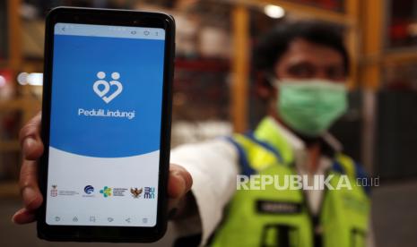 Petugas bandara menunjukan aplikasi PeduliLindungi yang ada di telepon genggamnya di Bandara Soekarno Hatta, Tangerang, Banten. PT Angkasa Pura II selaku pengelola sejumlah bandara di Indonesia mewajibkan calon penumpang pesawat yang akan terbang memiliki aplikasi PeduliLindungi, hal tersebut untuk mendukung penerapan Surat Edaran Menteri Kesehatan tentang Digitalisasi dokumen kesehatan bagi pengguna transportasi udara yang terintegrasi dengan aplikasi tersebut. 