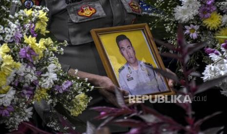 Petugas kepolisian membawa foto jenazah almarhum Aiptu Anumerta Sofyan saat prosesi pemakaman di pemakaman keluarga Jalan Sukahaji, Kecamatan Sukasari, Kota Bandung, Rabu (7/12/2022). Aiptu Anumerta Sofyan merupakan korban meninggal dunia dalam peristiwa ledakan bom bunuh diri di Polsek Astana Anyar, Kota Bandung.  