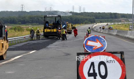 Pekerja memperbaiki jalan yang rusak di  Tol Trans Sumatera (JTTS) kilometer 191  Ruas Terbanggibesar-Pematangpanggang-Kayuagung, Lampung, Selasa (15/12/2020). Jalan yang rusak tersebut diperbaiki untuk keamanan dan kenyamanan pengguna tol terutama yang melakukan perjalanan libur Natal dan Tahun Baru 2021. 