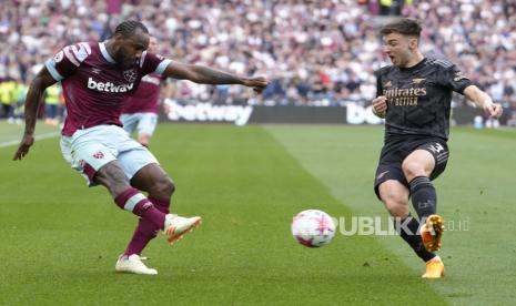 Michail Antonio dari West Ham, kiri, ditantang oleh Kieran Tierney dari Arsenal selama pertandingan sepak bola Liga Premier Inggris antara West Ham United dan Arsenal di stadion London di London, Ahad, (16/4/2023).