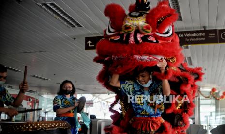 Seniman barongsai beratraksi di area Stasiun Lintas Raya Terpadu (LRT) Velodrome, Jakarta Timur, Selasa (1/2/2022). 