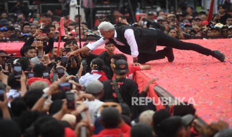 Calon presiden nomor urut 3 Ganjar Pranowo berbincang dengan pendukungnya saat mengikuti kampanye terbuka bertajuk Hajatan Rakyat di Alun-Alun Wates, Kulon Progo, Yogyakarta, Ahad (28/1/2024). Dalam kampanyenya Ganjar mengatakan ia akan memilih meningkatkan taraf pendidikan masyarakat agar tercipta satu sarjana dari tiap keluarga daripada memberi makan siang gratis. 