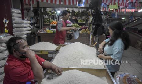 Pedagang beras melayani pembeli di kiosnya di Pasar Atas Cimahi, Kota Cimahi, Jawa Barat, Jumat (8/9/2023). 