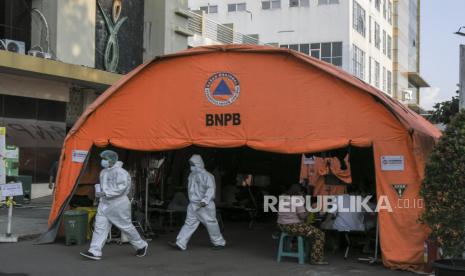 Sejumlah petugas medis berjalan usai melakukan perawatan pasien di tenda darurat yang dijadikan IGD (Instalasi Gawat Darurat) di RSUD Bekasi, Jawa Barat, Jumat (25/6/2021). Pemerintah setempat memindahkan ruang IGD ke tenda darurat karena keterbatasan tempat, akibat lonjakan kasus pasien COVID-19 yang mencapai 368 jiwa. 