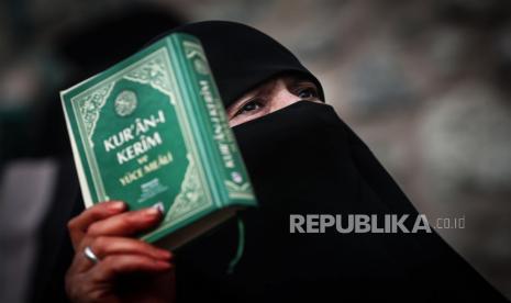 Seorang demonstran wanita memegang Alquran saat melakukan protes di depan Konsulat Jenderal Swedia, di Istanbul, Turki, 22 Januari 2023. Demonstran berkumpul setelah politikus sayap kanan Swedia-Denmark Rasmus Paludan diizinkan menggelar demonstrasi dan membakar salinan Alquran di depan kedutaan Turki di Stockholm pada 21 Januari 2023.