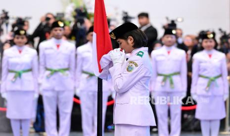 Anggota Paskibraka 2024 asal Sumatera Utara Violetha Agryka Sianturi mencium Bendera Merah-Putih dalam pengukuhan Paskibraka Tingkat Pusat 2024 di Istana Negara, Ibu Kota Nusantara (IKN), Kalimantan Timur, Selasa (13/8/2024). Presiden mengukuhkan 76 anggota Paskibraka 2024 yang nantinya akan bertugas di Istana Negara, IKN pada 17 Agustus 2024.