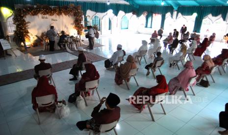 Sejumlah anggota keluarga pasangan pengantin duduk dengan jarak saat mengikuti prosesi akad nikah. Pemkab Trenggalek izinkan hajatan digelar asal terapkan protokol kesehatan. Ilustrasi.