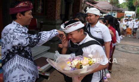 Sejumlah murid berbaris sambil menyalami guru saat perayaan Hari Guru di SMP Negeri 1 Denpasar, Bali, Sabtu (25/11/2023). Kegiatan tersebut digelar sebagai ungkapan rasa kasih sayang dan terima kasih dari murid kepada gurunya dalam memperingati Hari Guru Nasional 2023. 