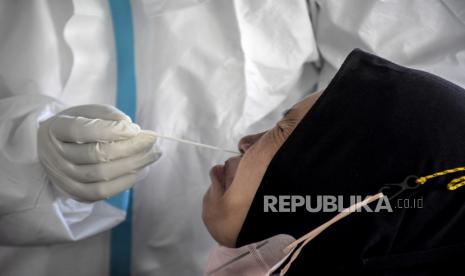 Petugas kesehatan melakukan tes usap PCR kepada calon haji di area Masjid Pusdai, Kota Bandung, Selasa (28/6/2022). Sebanyak 228 jamaah calon haji kloter terakhir asal Kota Bandung mengikuti tes usap PCR dan uji kehamilan, sebagai salah satu persyaratan keberangkatan haji serta untuk memastikan jamaah calon haji bebas dari Covid-19. Foto: Republika/Abdan Syakura 