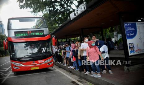 Warga antre untuk menaiki bus wisata Transjakarta dengan atap terbuka dengan rute Monas hingga Bundaran Senayan, Jakarta, Jumat (20/1/2023).