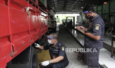 Petugas melakukan uji kir berkala kendaraan.