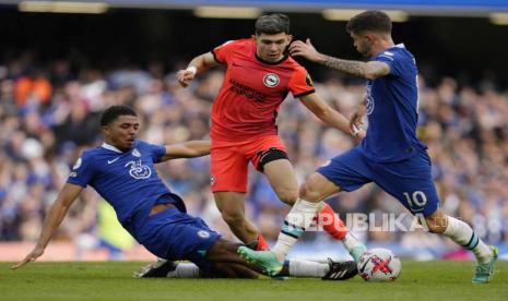 Pemain Brighton Julio Enciso (tengah) dihadang oleh pemain Chelsea Wesley Fofana (kiri) dan Christian Pulisic pada pertandingan sepak bola Liga Premier Inggris antara Chelsea dan Brighton dan Hove Albion di stadion Stamford Bridge di London, Sabtu (15/4/2023).