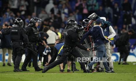 Petugas Polisi Nasional Spanyol berusaha menghentikan suporter Espanyol yang menyerbu lapangan setelah kalah dalam pertandingan sepak bola LaLiga Spanyol antara RCD Espanyol dan FC Barcelona, ??di Barcelona, ??Catalonia, Spanyol, Senin (15/5/2023) dini hari WIB.3.