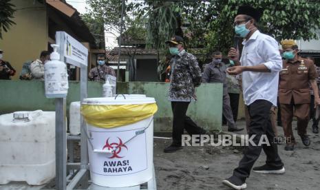 Menteri Koordinator Bidang Pembangunan Manusia dan Kebudayaan Muhajir Effendy (kiri) didampingi Lurah Panggungharjo Wahyudi Anggoro Hadi (kedua kanan) meninjau penerapan Pemberlakuan Pembatasan Kegiatan Masyarakat (PPKM) Mikro di Panggungharjo, Sewon, Bantul, DI Yogyakarta, Kamis (18/2/2021). Menko PMK Muhajir Effendy melihat penerapan PPKM Mikro Desa Panggungharjo yang menyediakan posko edukasi dan pengendalian penularan COVID-19 serta lokasi isolasi. 