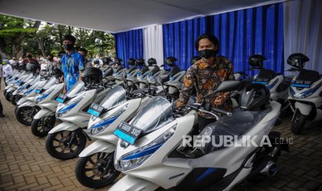 Petugas memeriksa kompartemen motor listrik saat penyerahan motor listrik bagi Aparatur Sipil Negara (ASN) di Balai Kota Bandung, Jawa Barat, Rabu (24/2/2021). Pemerintah Kota Bandung bekerja sama dengan PT HPP Energy Indonesia melaksanakan program pinjam pakai 22 unit sepeda motor listrik yang ditujukan sebagai kendaraan operasional ASN guna mendorong keberadaan kendaraan listrik yang dapat mengurangi polusi di Kota Bandung. 