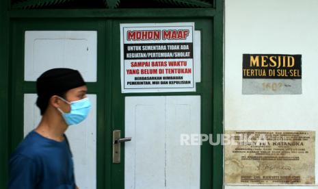 PP Muhammadiyah Tanggapi Soal Wacana Relaksasi Rumah Ibadah:   Warga melintas di depan pintu Masjid Tua Katangka yang dipasangi poter pengumuman di Kabupaten Gowa, Sulawesi Selatan, Selasa (5/5/2020). Masjid Tua Katangka yang dibangun pada tahun 1603 dan menjadi destinasi wisata religi yang ramai dikunjungi wisatawan saat Ramadhan tersebut ditutup sementara akibat adanya penerapan Pembatasan Sosial Berskala Besar (PSBB) di daerah itu guna memutus rantai penyebaran virus Corona