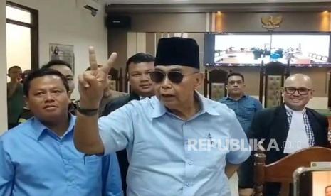 Pimpinan Mahad Al-Zaytun Indramayu, Panji Gumilang, menjelaskan tentang arti acungan dua jari yang dilakukannya usai sidang, di PN Indramayu, Kamis (29/2/2024). 