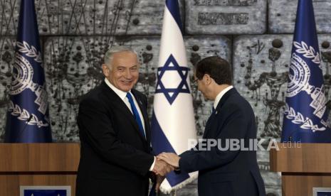 Pemimpin Partai Likud Israel Benjamin Netanyahu, kiri, dan Presiden Israel Isaac Herzog berjabat tangan setelah Herzog menugaskan Netanyahu untuk membentuk pemerintahan, di Yerusalem, Ahad, 13 November 2022. Rabi Amerika Utara: Pemerintahan Baru Israel Ancaman Bagi Yahudi dan Palestina