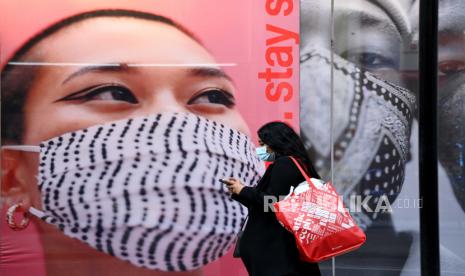  Pejalan kaki yang mengenakan masker pelindung wajah berjalan di Jalan Oxford, London. Wali Kota London Sadiq Khan wajibkan warga bermasker di transportasi umum. Ilustrasi. 