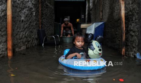 Warga beraktivitas di pemukiman yang terdampak banjir sedalam 60-100 cm di kawasan Petukangan, Kecamatan Cakung, Jakarta Timur, Rabu (29/1/2025).