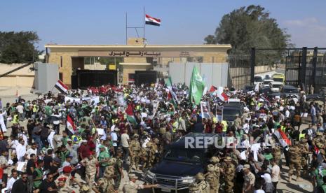 Warga Mesir mengibarkan bendera nasional dan bendera Palestina sebagai Sekretaris Jenderal PBB Antonio Guterres tiba di perbatasan Raffa-Mesir, (20/10/2023). 