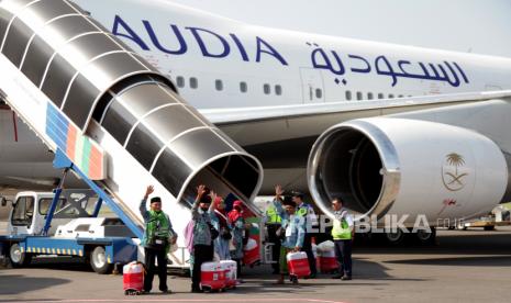 Jamaah calon haji kelompok terbang (kloter) pertama embarkasi Surabaya melambaikan tangan saat berjalan menuju pesawat di Bandara Internasional Juanda Surabaya di Sidoarjo, Jawa Timur, Rabu (24/5/2023). Sebanyak 445 jamaah calon haji kloter pertama embarkasi Surabaya dari kabupaten Bangkalan diberangkatkan ke Madinah, Arab Saudi. 