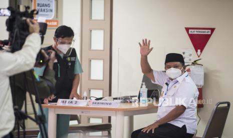 Wakil Gubernur Jawa Barat Uu Ruzhanul Ulum (kanan) melambaikan tangan sebelum vaksinasi COVID-19 Sinovac di Rumah Sakit Hasan Sadikin (RSHS), Bandung, Jawa Barat, Kamis (14/1/2021). Uu Ruzhanul Ulum menjadi orang pertama di Provinsi Jawa Barat yang menerima vaksinasi COVID-19 Sinovac menandakan dimulainya program vaksinasi massal di sejumlah daerah di Jawa Barat. 